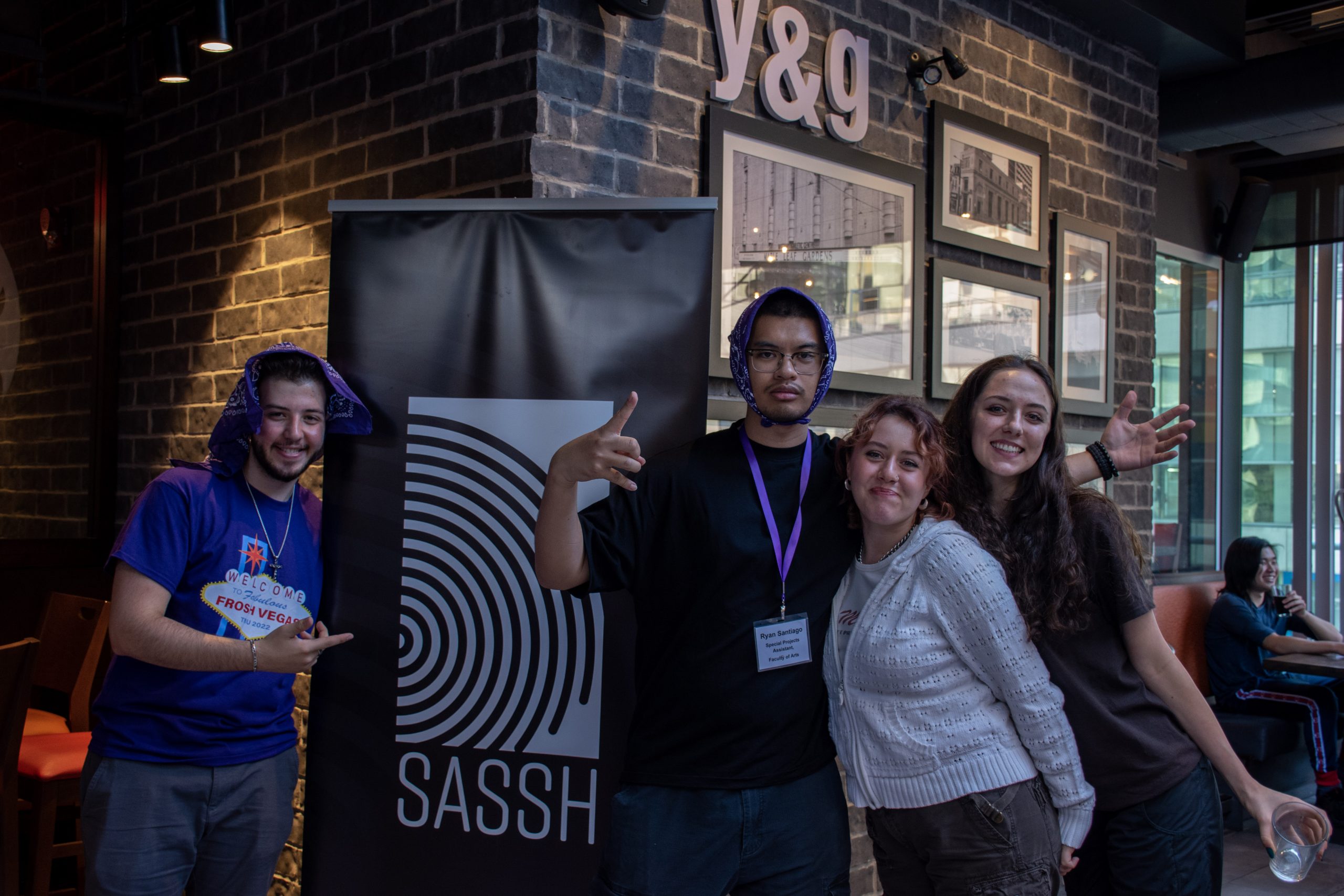 students posing by a SASSH banner